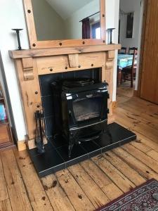 a woodburning stove in a living room with a counter at Comfortably Crolly Holiday Home in Letterkenny