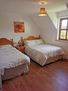 1 dormitorio con 2 camas y ventana en Comfortably Crolly Holiday Home, en Letterkenny