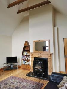 ein Wohnzimmer mit einem Kamin und einem TV in der Unterkunft Comfortably Crolly Holiday Home in Letterkenny