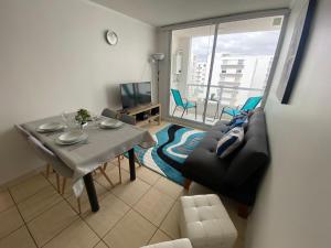 una pequeña sala de estar con mesa y sofá en Fantástico departamento en la Serena al lado de la playa, en La Serena