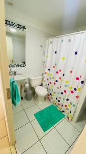 y baño con aseo y cortina de ducha. en Fantástico departamento en la Serena al lado de la playa, en La Serena
