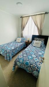 1 dormitorio con 2 camas y ventana en Fantástico departamento en la Serena al lado de la playa, en La Serena