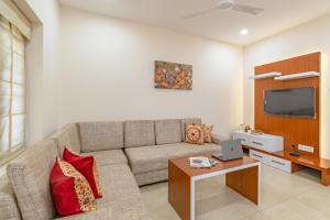 sala de estar con sofá y TV en StayVista at Anjali with Free Breakfast & Terrace Access, en Kozhikode