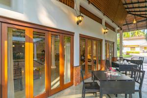 comedor con mesa y sillas en el patio en StayVista at Anjali with Free Breakfast & Terrace Access, en Kozhikode