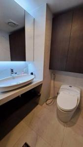 a bathroom with a white toilet and a sink at Aston Apartment Batam Floor 21 in Nagoya