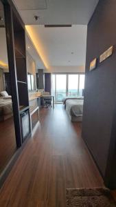 ein Hotelzimmer mit einem Schlafzimmer mit einem Bett und einem großen Fenster in der Unterkunft Aston Apartment Batam Floor 21 in Nagoya