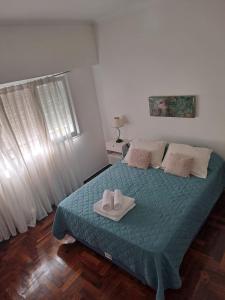 1 dormitorio con 1 cama con 2 zapatillas en TU SUEÑO en Mar del Plata