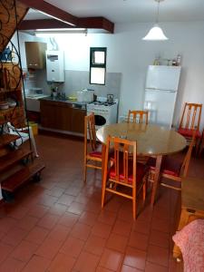 cocina con mesa de madera y sillas y cocina con nevera en Castillo Del Lago - Carlos Paz - D17 en Villa Carlos Paz