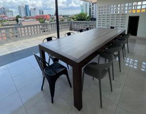 9 Residence Guesthouse Syariah Cilandak في جاكرتا: طاولة وكراسي خشبية فوق شرفة