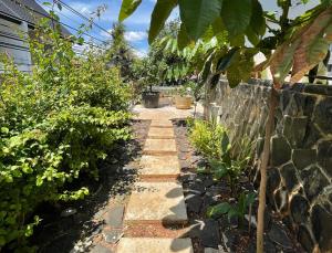 a garden path next to a stone wall at 9 Residence Guesthouse Syariah Cilandak in Jakarta