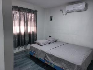 a small bedroom with a bed and a window at Habitación Suites Playas in Playas