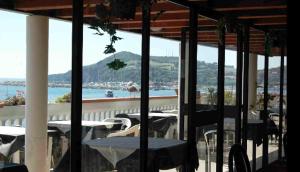 einen Balkon mit Tischen und Stühlen und Blick auf das Wasser in der Unterkunft Hotel Esperia in Piombino