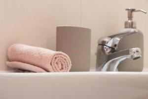 zlew w łazience z różowym ręcznikiem obok kranu w obiekcie BR Homes w Budapeszcie