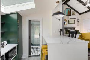 a kitchen with a green and white counter top at The Cozy Yellow Cottage in Dilworth in Charlotte