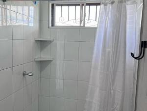 y baño con ducha y cortina de ducha. en Wally’s Place en Estelí