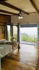 ein Schlafzimmer mit einem Bett und einem großen Fenster in der Unterkunft Cabina Las Nubes in Quesada