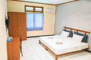 a bedroom with two beds and a television in it at INAGRO in Bogor