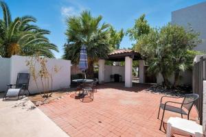 un patio con sillas, mesas y palmeras en Heart of Old Town Scottsdale en Scottsdale