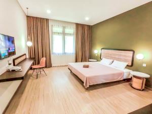 a hotel room with a large bed and a television at INAGRO in Bogor