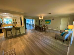 a living room and kitchen with a couch and a table at Blue Heron House, Private 4 BR Waterfront w Heated Pool and Fire Pit in Ruskin