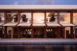 a building with windows and tables and chairs at Park Hyatt Maldives Hadahaa in Gaafu Alifu Atoll