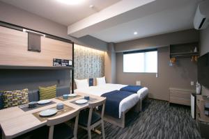 ein Hotelzimmer mit einem Bett und einem Tisch in der Unterkunft Minn Kappabashi in Tokio