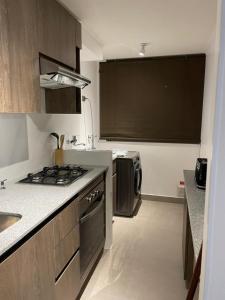 uma pequena cozinha com um fogão e um lavatório em Departamento con vista al mar em Iquique