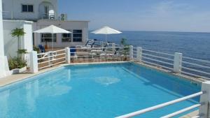a swimming pool with a view of the ocean at Hotel Ariana in Marine du Miomo