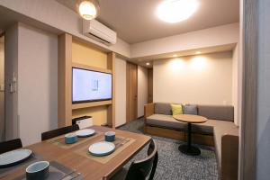 ein Wohnzimmer mit einem Tisch und einem Sofa in der Unterkunft Minn Kappabashi in Tokio
