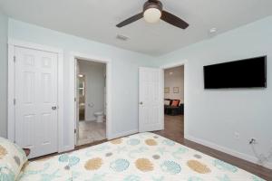 a living room with a ceiling fan and a flat screen tv at Stylish 2 bedroom home close 2 dtown, nas, and bch in Pensacola