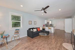 a living room with a black couch and a ceiling fan at Stylish 2 bedroom home close 2 dtown, nas, and bch in Pensacola