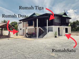 Una casa con dos flechas apuntando a la parte delantera. en VillaKampung, en Kuala Terengganu