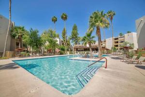 a swimming pool with palm trees in a resort at Walk to Old Town Scottsdale in Scottsdale