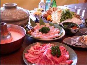 uma mesa com muitos pratos de comida em Mountside Jodel em Hakuba