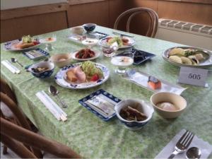 uma mesa com pratos de comida por cima em Mountside Jodel em Hakuba