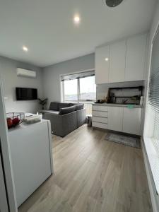 een keuken en een woonkamer met witte kasten bij Howrah Getaway (Entire Place, Private Entrance, Breakfast included) in Howrah