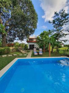 une image d'une piscine en face d'une maison dans l'établissement Adama Farmhouse @ Hacienda San Benito, à San Celestino