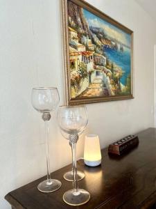two wine glasses sitting on a table with a painting at Cozy Private Condo near Hall of Fame in Hollywood in Los Angeles