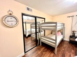a room with two bunk beds and a clock on the wall at Cozy Private Condo near Hall of Fame in Hollywood in Los Angeles