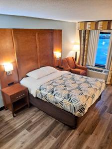 ein Hotelzimmer mit einem Bett und einem Stuhl in der Unterkunft Motel 6 Catonsville MD Baltimore West in Catonsville