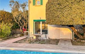 een huis met een tafel en stoelen naast een zwembad bij Gorgeous Apartment In Ginasservis With Wifi in Ginasservis