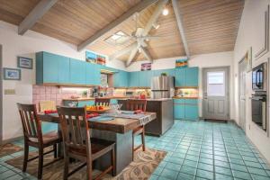 a kitchen with blue cabinets and a table and chairs at Beautiful Spacious Home in Paradise in Waikoloa Village