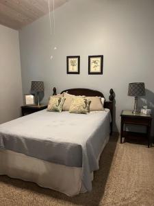 a bedroom with a bed with two tables and two lamps at Beautiful Spacious Home in Paradise in Waikoloa Village