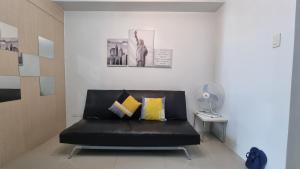 a black leather couch sitting in a room at Sea Residences EZBedz in Manila