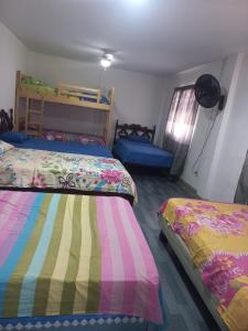 a bedroom with two beds and a bunk bed at Habitaciones Grupales in Playas