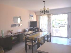 ein Wohnzimmer mit einem Esstisch und einem TV in der Unterkunft Appartement Marseillan-Plage, 3 pièces, 6 personnes - FR-1-387-134 in Le Castellas