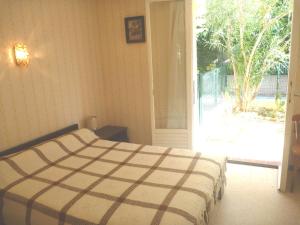 Schlafzimmer mit einem Bett und einer Glasschiebetür in der Unterkunft Appartement Marseillan-Plage, 3 pièces, 6 personnes - FR-1-387-134 in Le Castellas