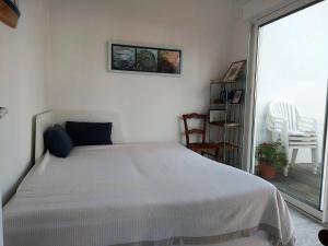 ein weißes Schlafzimmer mit einem Bett und einem Balkon in der Unterkunft Maison Noirmoutier-en-l'Île, 3 pièces, 4 personnes - FR-1-224B-90 in Noirmoutier-en-l'lle