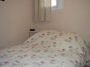 Una cama con una manta con flores. en Appartement Les Angles, 2 pièces, 4 personnes - FR-1-593-37, en Les Angles