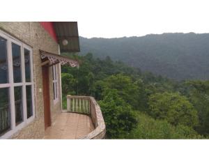 un balcón de una casa con vistas a las montañas en Silent Valley Resort,Lamagaon, en Bijanbāri Bāzār